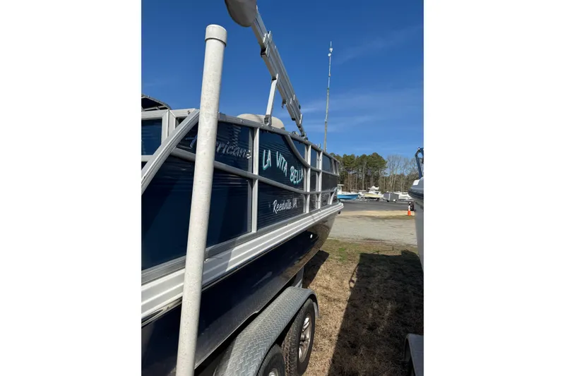 Slide: The Image of 2022 Hurricane FunDeck 1960 RE boat on trailer, parked outdoors under clear blue sky. - 13