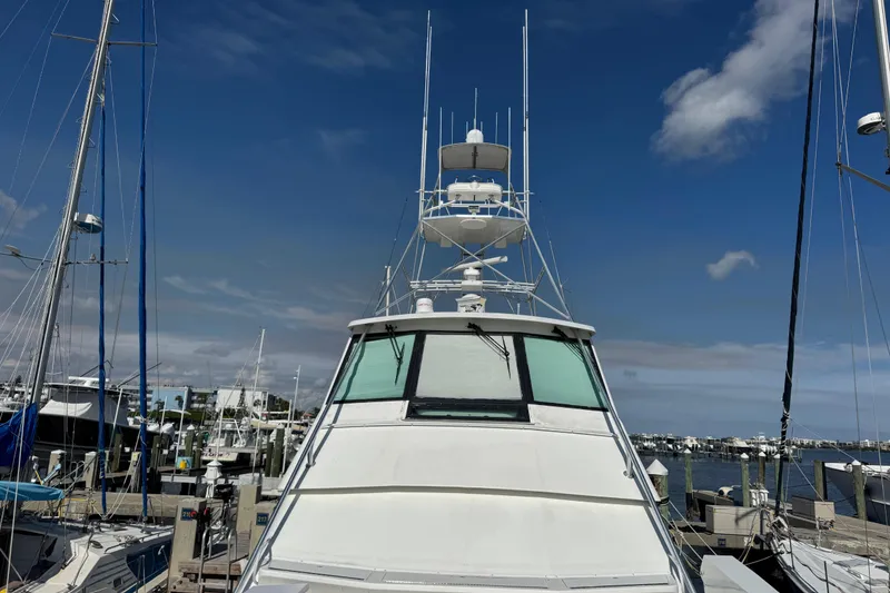 Slide: The Image of 1995 Viking 58 Convertible yacht docked at marina under clear blue sky. - 14