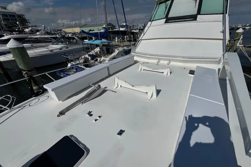 Slide: The Image of 1995 Viking 58 Convertible yacht deck in marina, showcasing sleek design and equipment. - 16