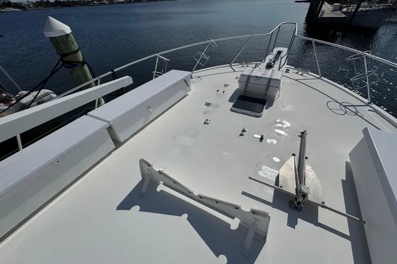 Slide: The Image of Bow of 1995 Viking 58 Convertible yacht with anchor and railing, docked by the water. - 18