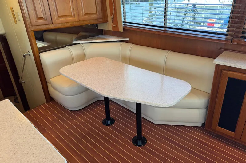 Slide: The Image of Interior of 1995 Viking 58 Convertible yacht with dining area and wooden flooring. - 23