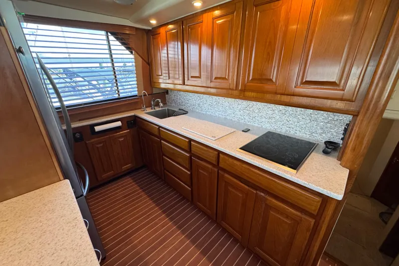 Slide: The Image of Luxurious kitchen interior of 1995 Viking 58 Convertible yacht with wooden cabinetry. - 25