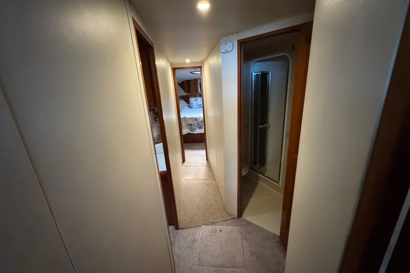 Slide: The Image of Hallway inside 1995 Viking 58 Convertible yacht, featuring bedroom and bathroom access. - 27