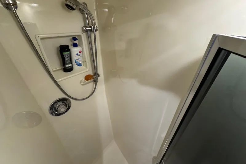 Slide: The Image of Shower area in 1995 Viking 58 Convertible yacht with toiletries and chrome fixtures. - 35