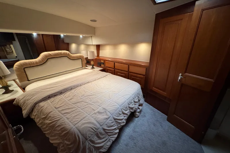 Slide: The Image of Luxurious bedroom interior of 1995 Viking 58 Convertible yacht with elegant wood finishes. - 36