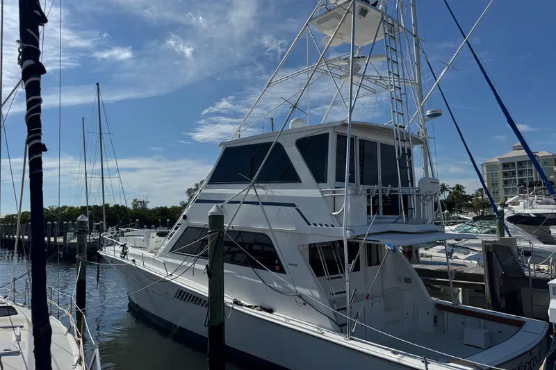 Slide: The Image of 1995 Viking 58 Convertible yacht docked at marina under clear blue sky. - 4
