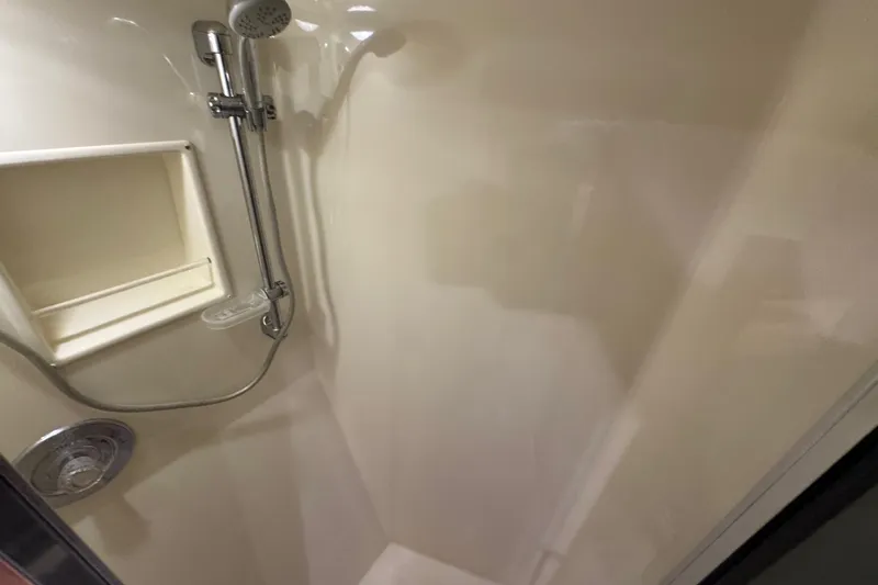Slide: The Image of Shower area in 1995 Viking 58 Convertible yacht, featuring chrome fixtures and built-in shelf. - 40