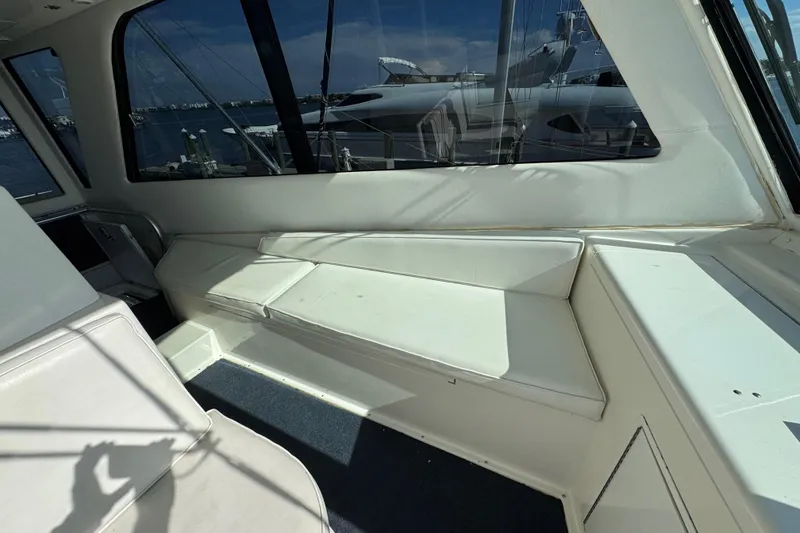 Slide: The Image of Interior view of a 1995 Viking 58 Convertible yacht with white seating and large windows. - 47