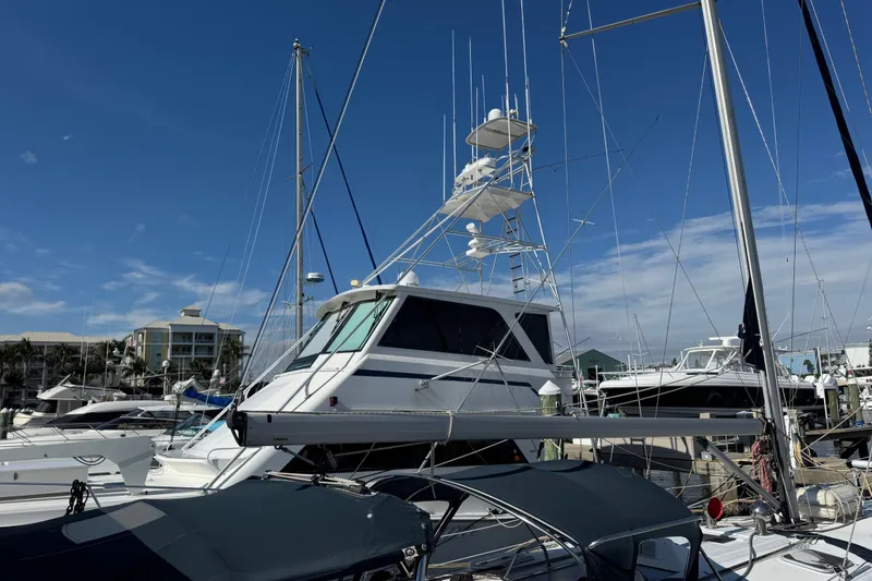 Slide: The Image of 1995 Viking 58 Convertible yacht docked at marina under clear blue sky. - 5