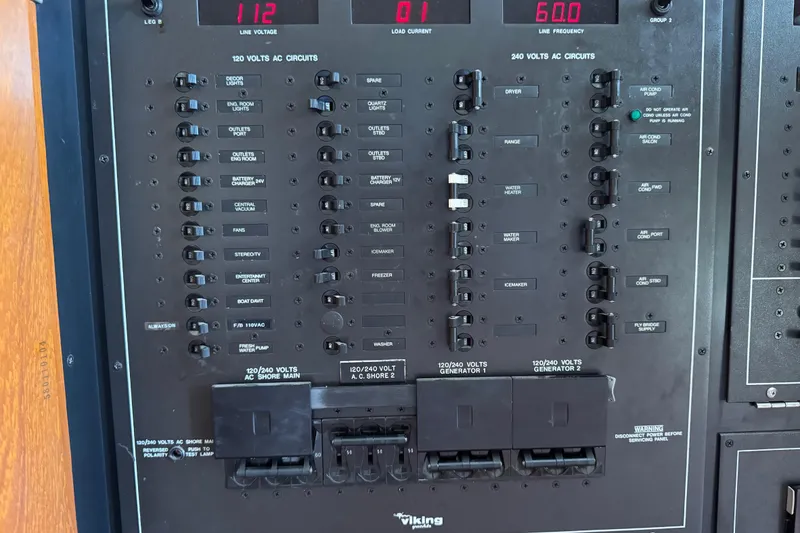 Slide: The Image of Electrical panel of a 1995 Viking 58 Convertible boat, showing various circuit controls. - 58