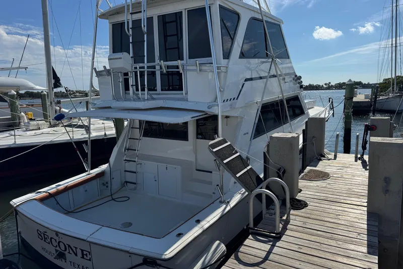 Slide: The Image of 1995 Viking 58 Convertible yacht docked at marina under clear blue sky. - 6