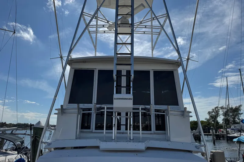 Slide: The Image of 1995 Viking 58 Convertible yacht with tower, docked under a clear blue sky. - 9