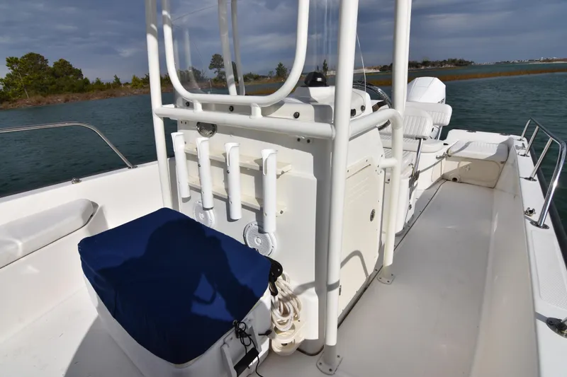 Slide: The Image of 2015 Boston Whaler 190 Montauk boat interior with seating and rod holders on a sunny day. - 15