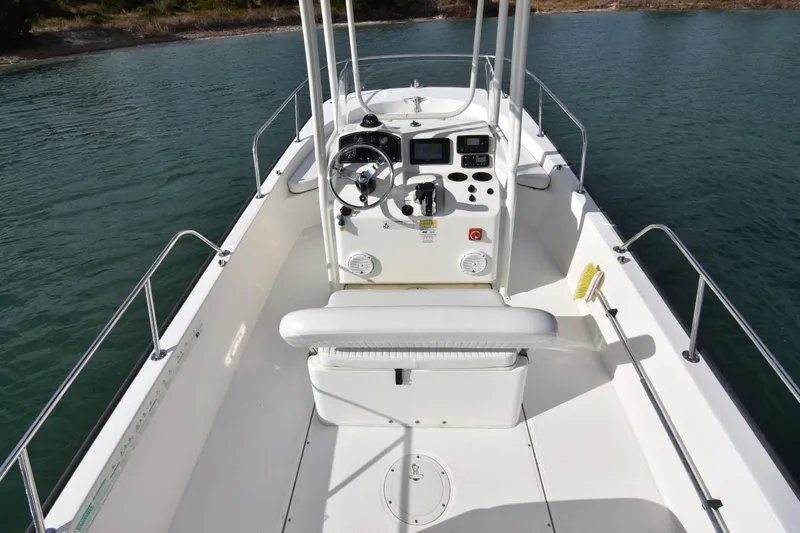 Slide: The Image of 2015 Boston Whaler 190 Montauk boat interior with steering console on calm water. - 17