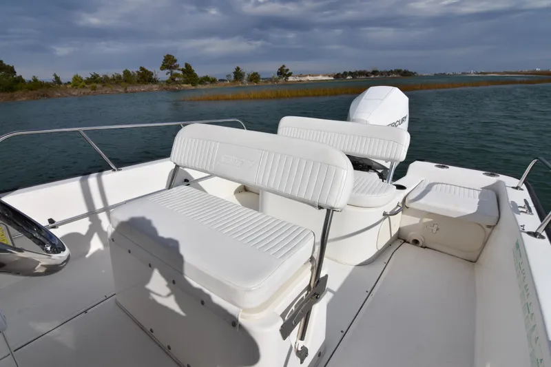 Slide: The Image of 2015 Boston Whaler 190 Montauk boat interior with white seating and scenic water view. - 4
