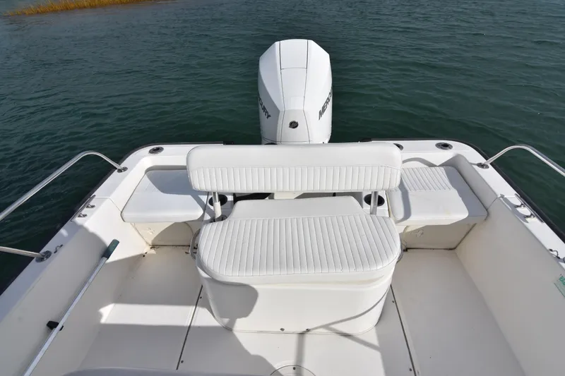 Slide: The Image of 2015 Boston Whaler 190 Montauk boat interior with seating and Mercury engine on water. - 5