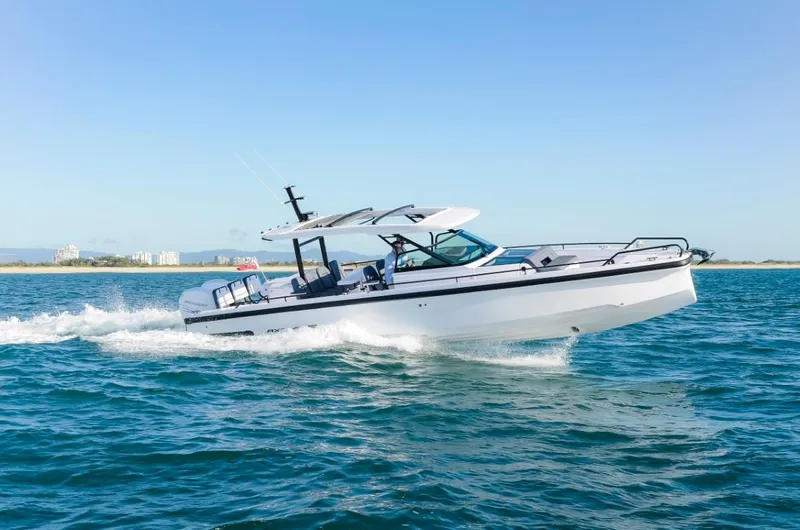 Slide: The Image of 2025 Axopar 37 Sun Top BRABUS Trim cruising on open water. - 2