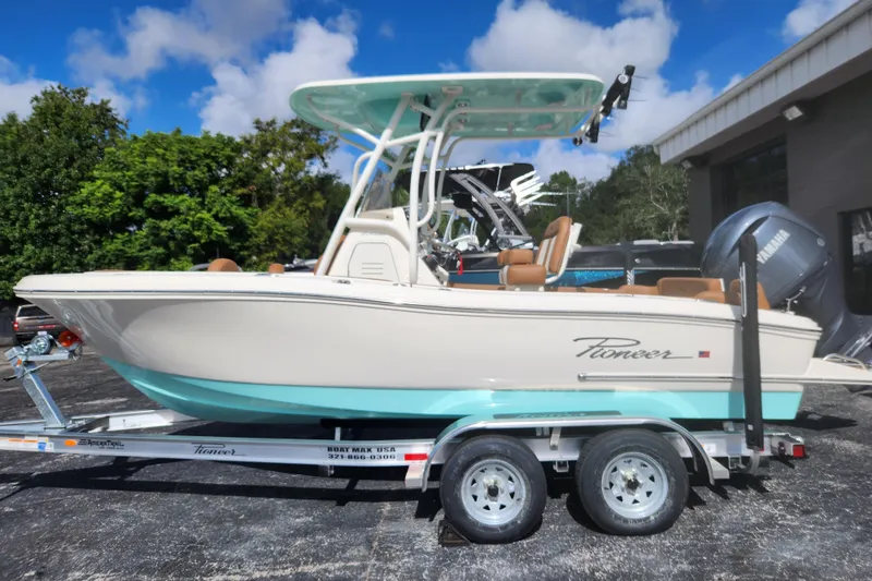 The Image of 2026 Pioneer 202 Islander boat on trailer, parked outdoors under blue sky. - 0