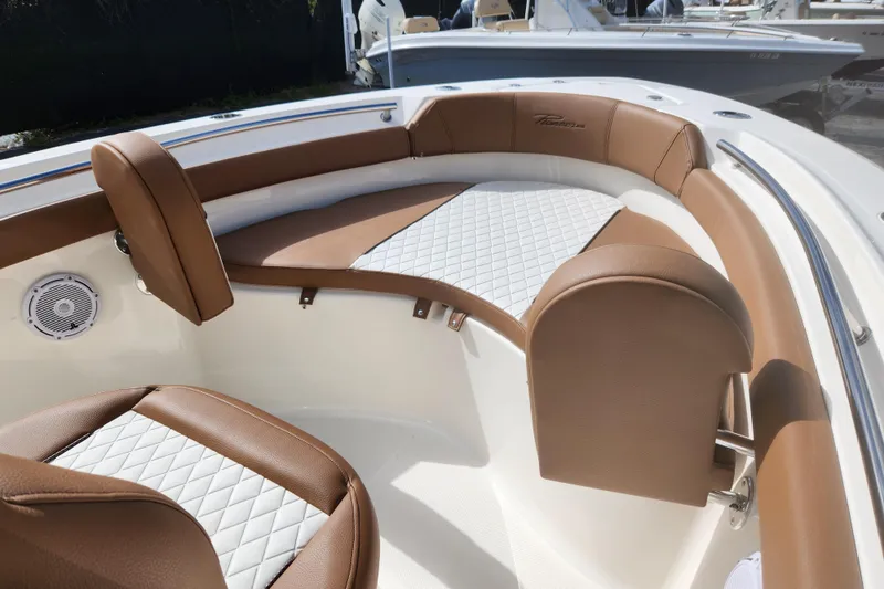Slide: The Image of 2026 Pioneer 202 Islander boat interior with brown and white cushioned seating. - 11