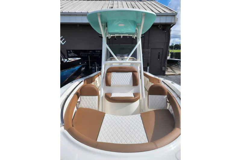 Slide: The Image of 2026 Pioneer 202 Islander boat interior with tan and white seating, under a teal canopy. - 9