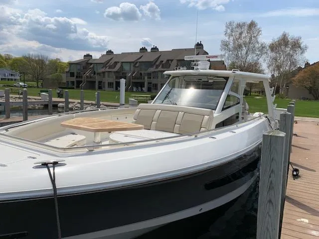 The Image of 2019 Boston Whaler 420 Outrage docked near waterfront dining area with umbrellas. - 0