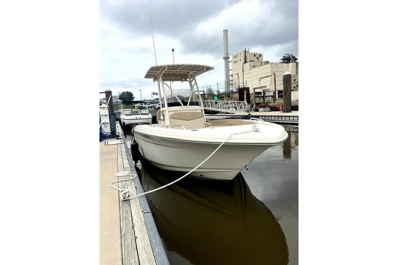 Slide: The Image of 2023 Scout 215 XSF boat docked at marina under cloudy sky. - 1
