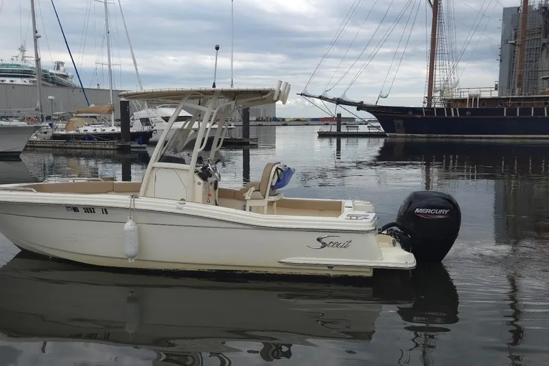 Slide: The Image of 2023 Scout 215 XSF boat docked in a marina with Mercury outboard motor. - 2
