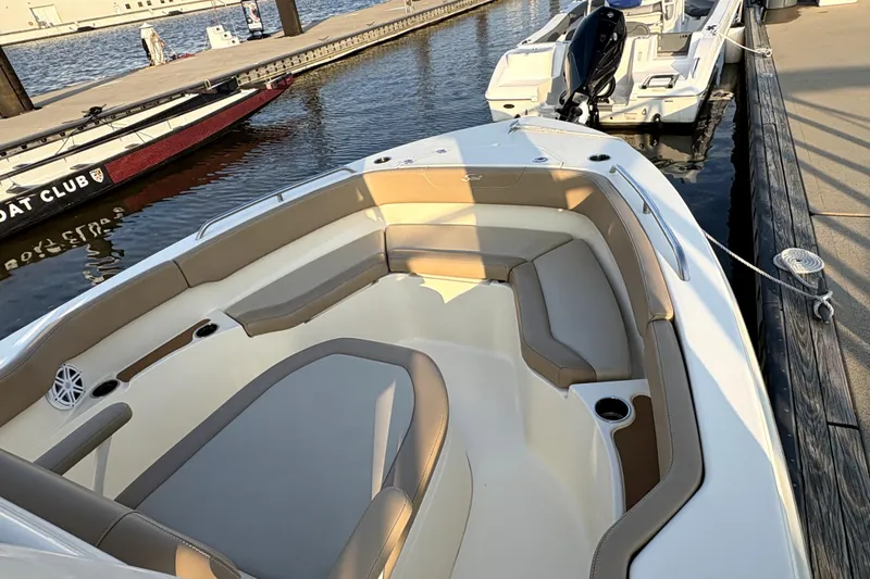 Slide: The Image of 2023 Scout 215 XSF boat docked, featuring spacious seating and modern design. - 9