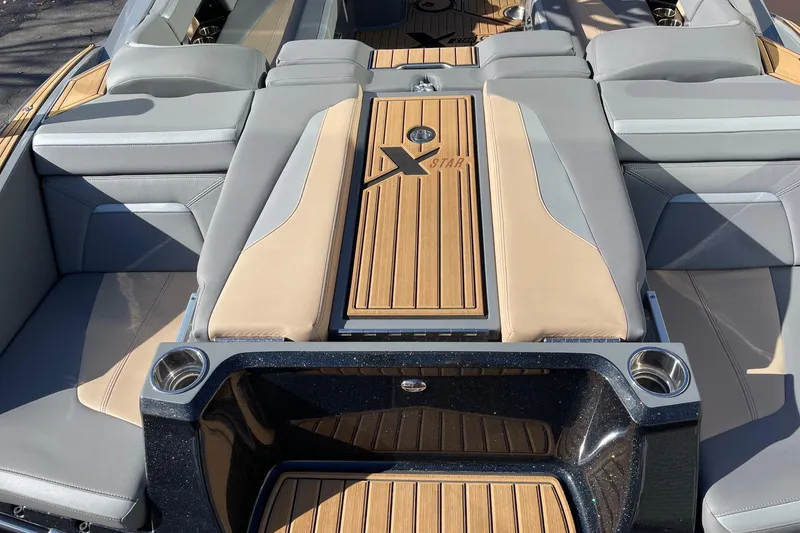 Slide: The Image of 2023 MasterCraft XStar S boat interior with luxurious seating and teak accents. - 4