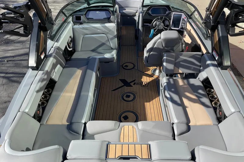 Slide: The Image of 2023 MasterCraft XStar S boat interior with luxurious seating and modern dashboard. - 5