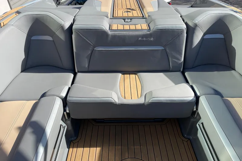 Slide: The Image of 2023 MasterCraft XStar S boat interior with luxurious seating and teak flooring. - 8