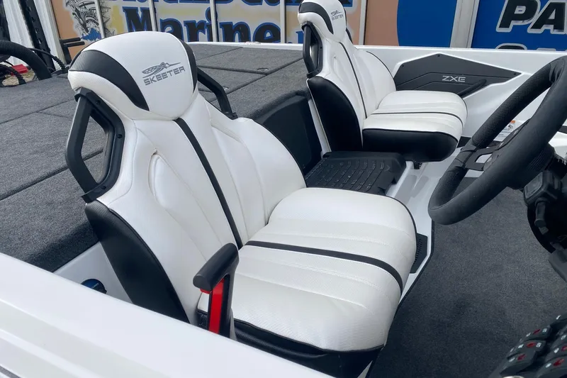 Slide: The Image of 2026 Skeeter ZXE21 boat interior with white and black seats, steering wheel visible. - 7