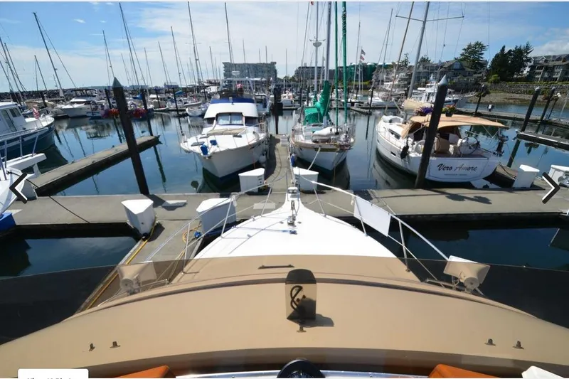 Slide: The Image of 1988 Canoe Cove Tri-Cabin yacht docked in a marina with surrounding boats. - 17