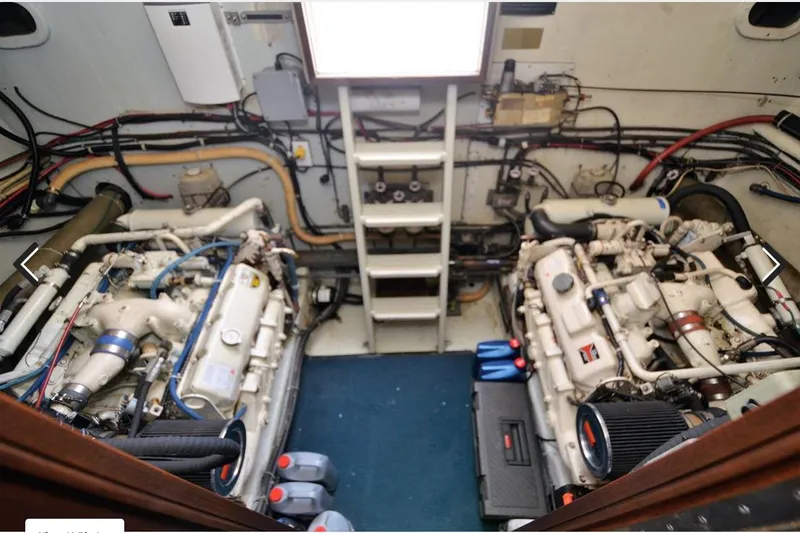 Slide: The Image of Engine room of 1988 Canoe Cove Tri-Cabin boat, featuring dual engines and various mechanical components. - 18