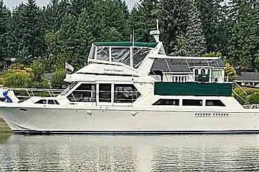 Slide: The Image of 1988 Canoe Cove Tri-Cabin yacht on calm water, surrounded by lush greenery. - 21