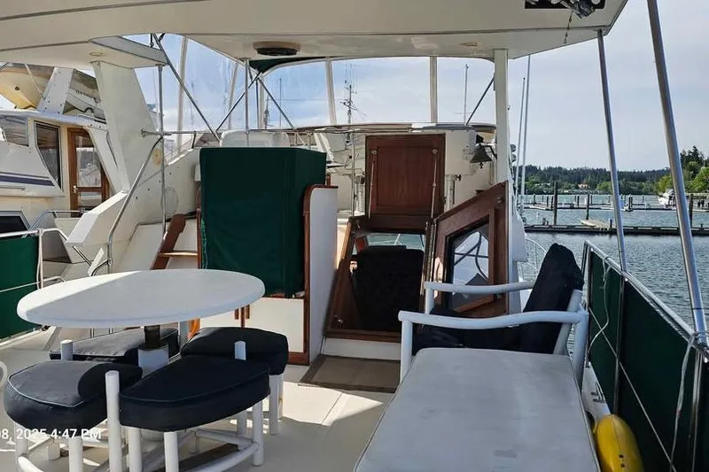 Slide: The Image of 1988 Canoe Cove Tri-Cabin yacht interior with seating and table, docked at marina. - 3