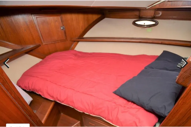 Slide: The Image of 1988 Canoe Cove Tri-Cabin interior with red bedding and wooden paneling. - 5