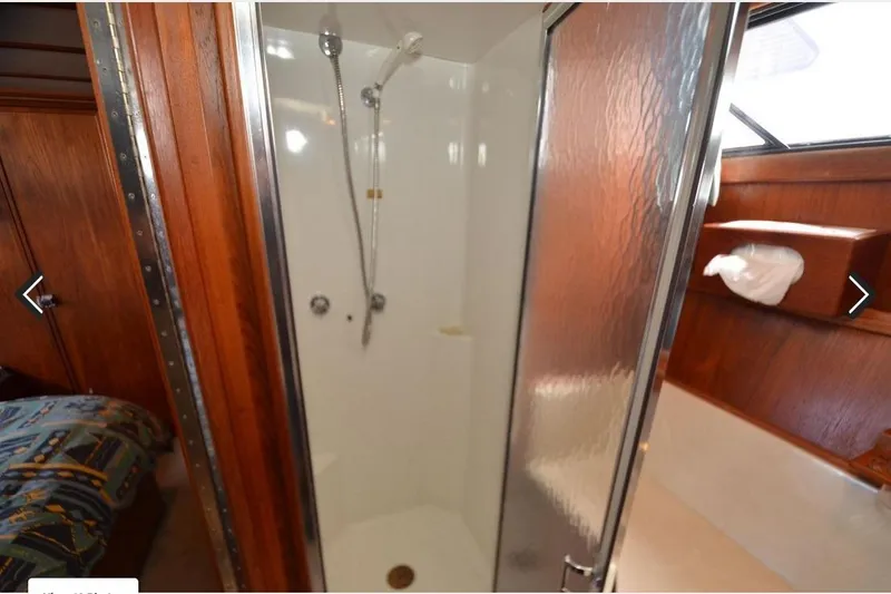 Slide: The Image of 1988 Canoe Cove Tri-Cabin shower with wooden accents and frosted glass door. - 9