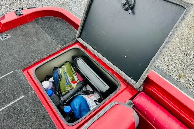 Slide: The Image of Open storage compartment in a 1997 Sprint 267 boat, containing various gear and supplies. - 17