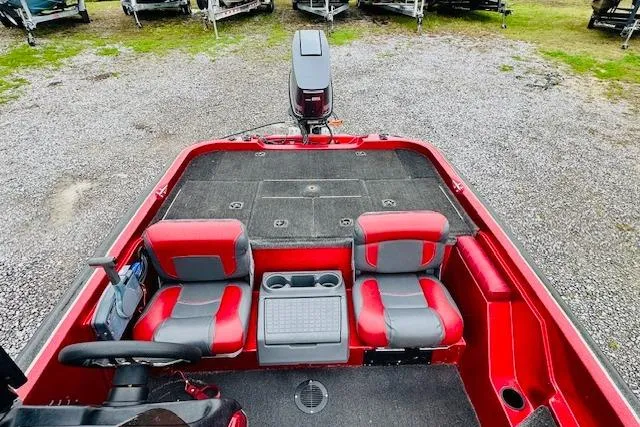 Slide: The Image of Red 1997 Sprint 267 boat interior with dual seats and motor, parked on gravel. - 23