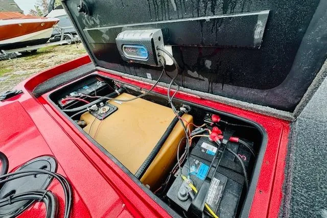 Slide: The Image of Open compartment of a 1997 Sprint 267 boat showing battery and wiring. - 24