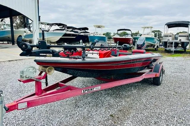 Slide: The Image of Red 1997 Sprint 267 boat on trailer, parked on gravel, surrounded by other boats. - 6