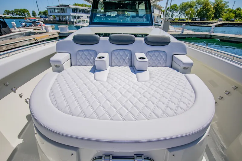 Slide: The Image of Luxurious lounging area on an HCB 56 GIX boat, surrounded by water and marina. - 15