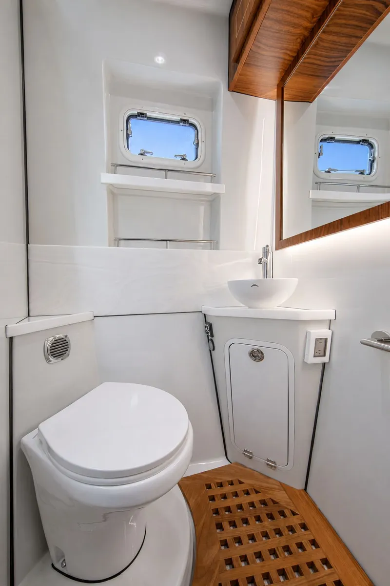 Slide: The Image of Interior view of a modern boat bathroom with toilet, sink, and wooden accents. - 25