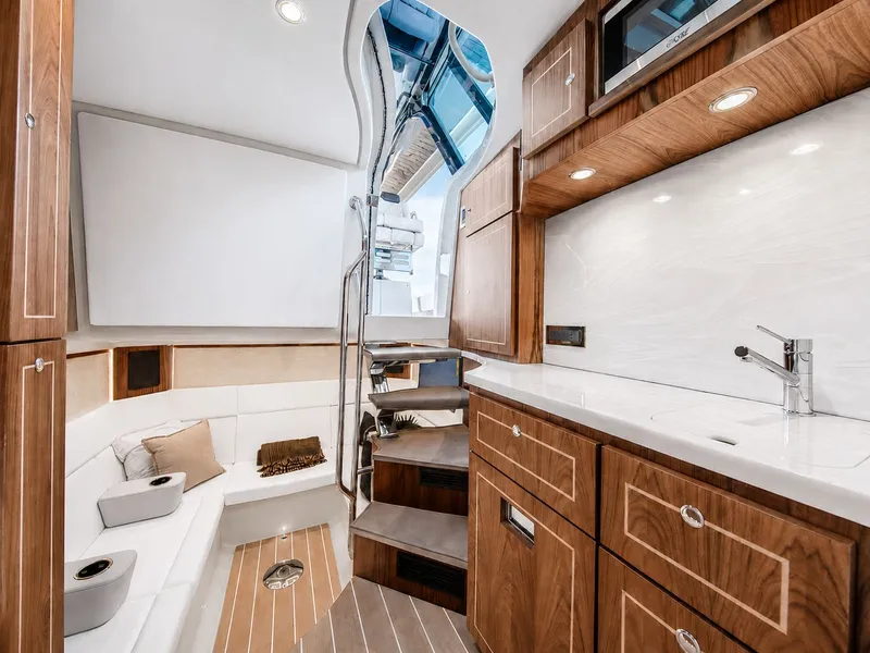 Slide: The Image of Interior of a luxury yacht with wood paneling, stairs, seating area, and sink. - 28