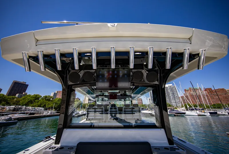 Slide: The Image of The image shows the stern of an HCB 56 GIX boat in a marina with rod holders. - 8