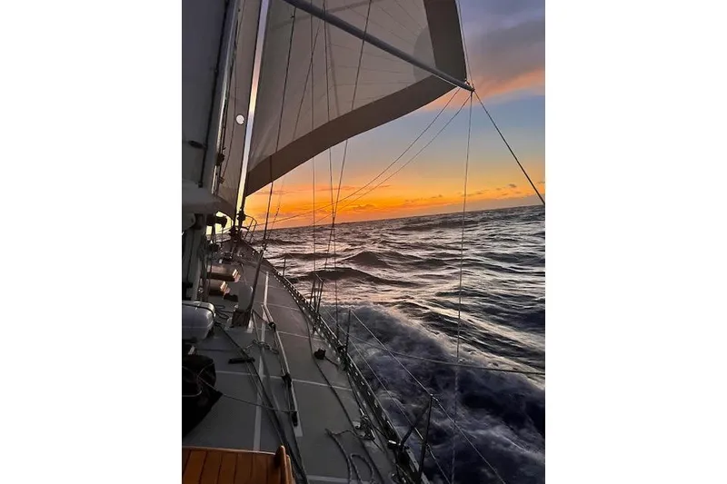Slide: The Image of Sailing at sunset on a 1985 Robert Clark Ketch, ocean waves in view. - 18