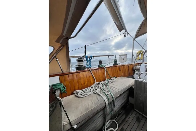 Slide: The Image of Cockpit view of 1985 Robert Clark Ketch sailboat with ropes and ocean backdrop. - 25