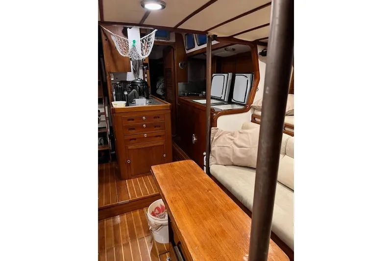 Slide: The Image of Interior of 1985 Robert Clark Ketch, featuring wooden cabinetry and cozy seating area. - 31