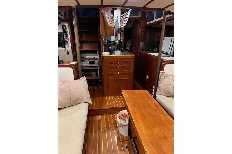 Slide: The Image of Interior of 1985 Robert Clark Ketch sailboat with wooden furnishings and cozy seating. - 34